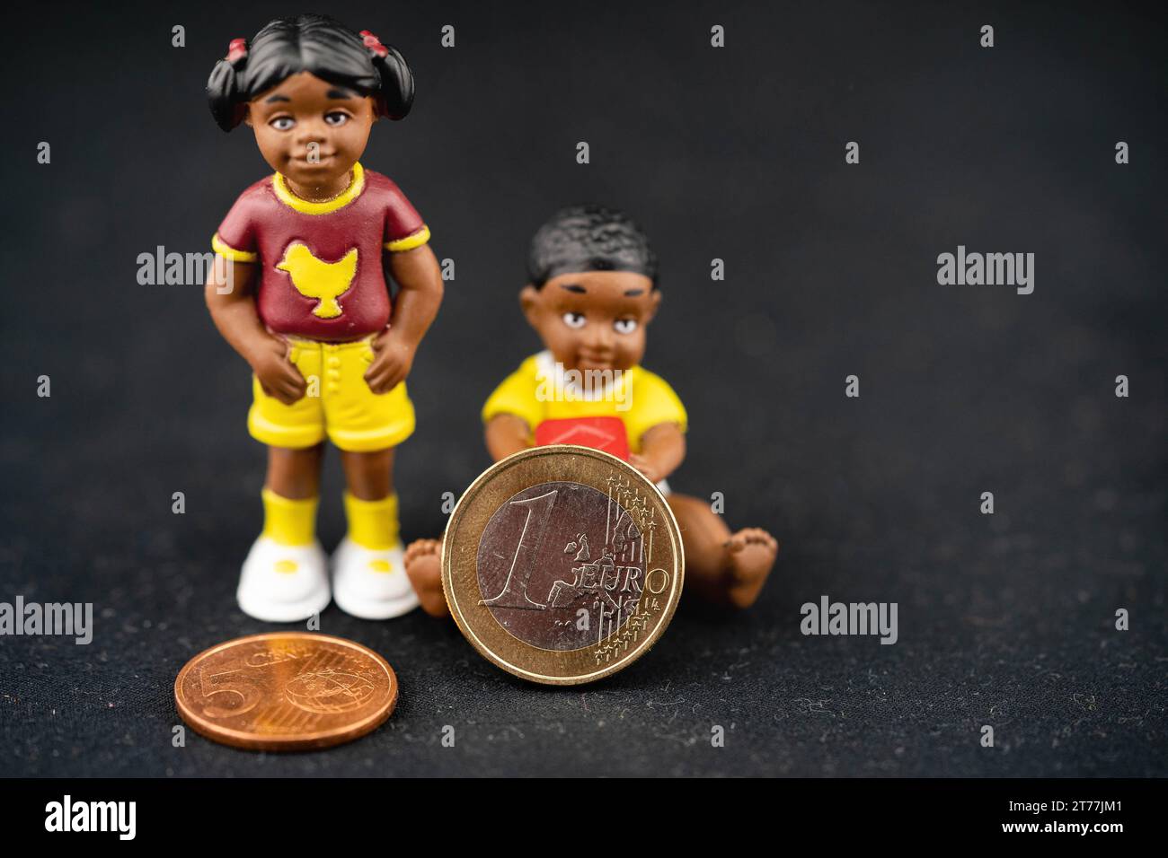 Kinderplastikfiguren mit Euro-Münzen, symbolisches Bild des Kindergeldes Stockfoto