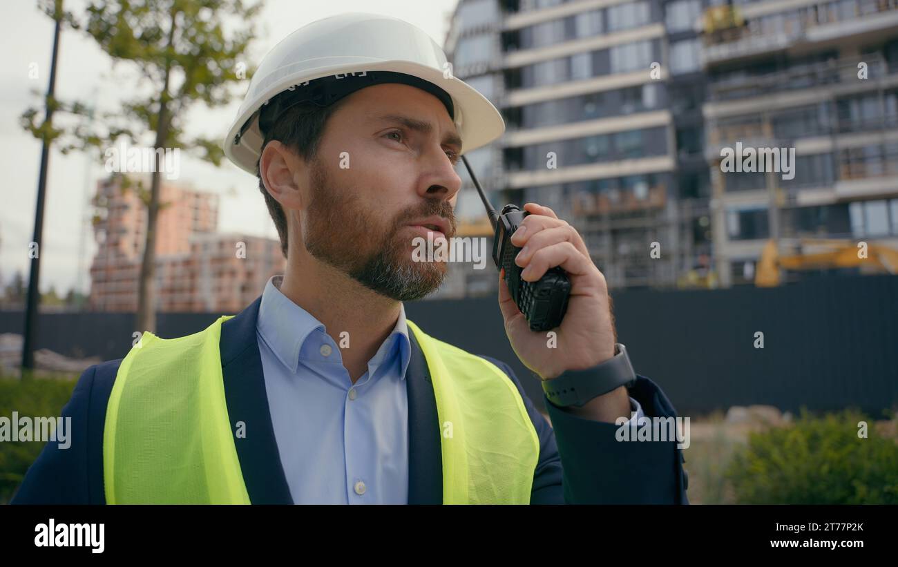 Kaukasischer Baumeister Architekt Ingenieur Auftragnehmer Reparaturarbeiter draußen in der Stadt Sprechen Sie mit Fernfunk Bau Stadtentwicklung Industrie Arbeiter in Stockfoto
