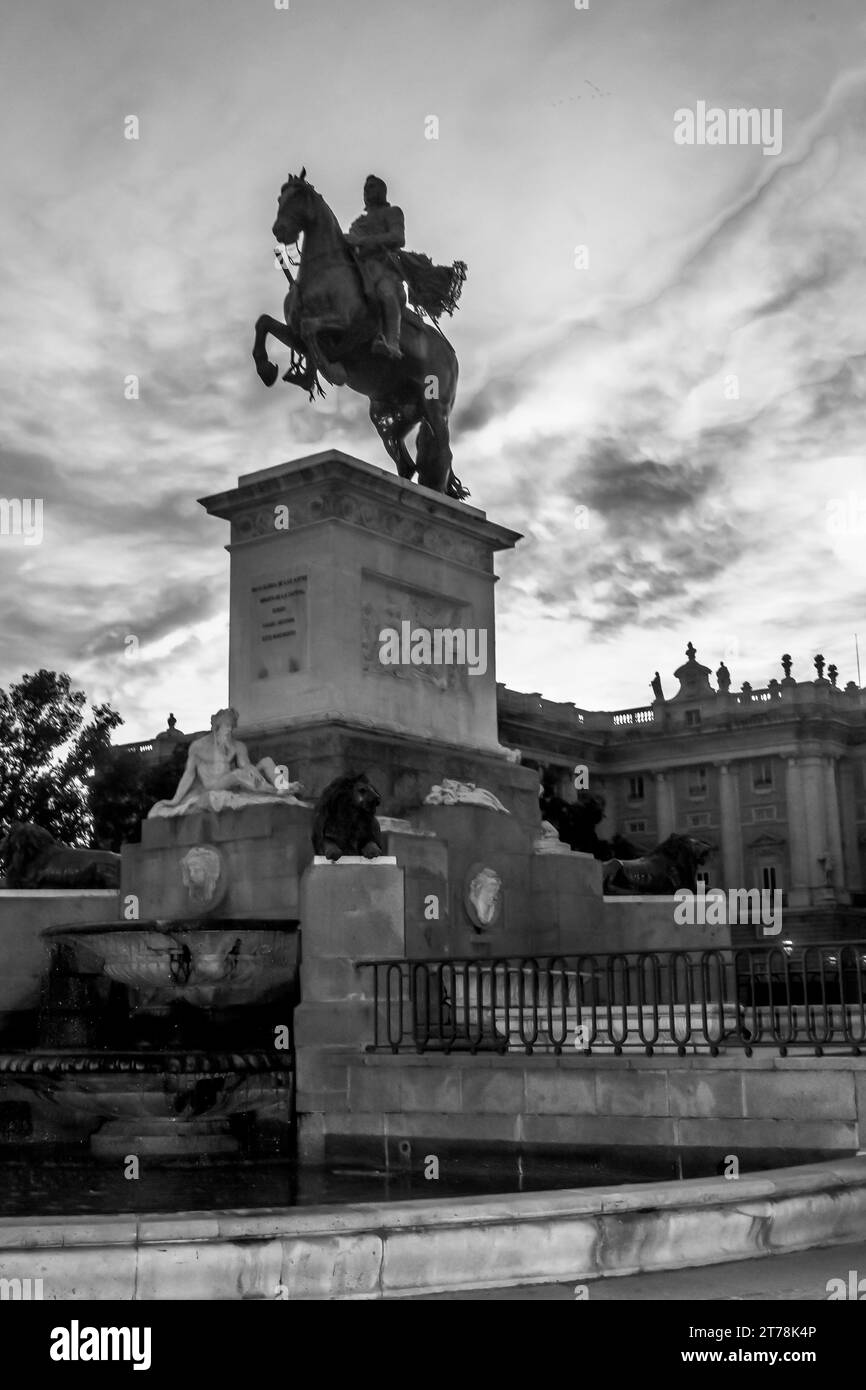 Silhouette des Felipe IV Monuments auf der Plaza de Oriente mit dunkelblauem Himmel und roten Wolken, Madrid Spanien Stockfoto