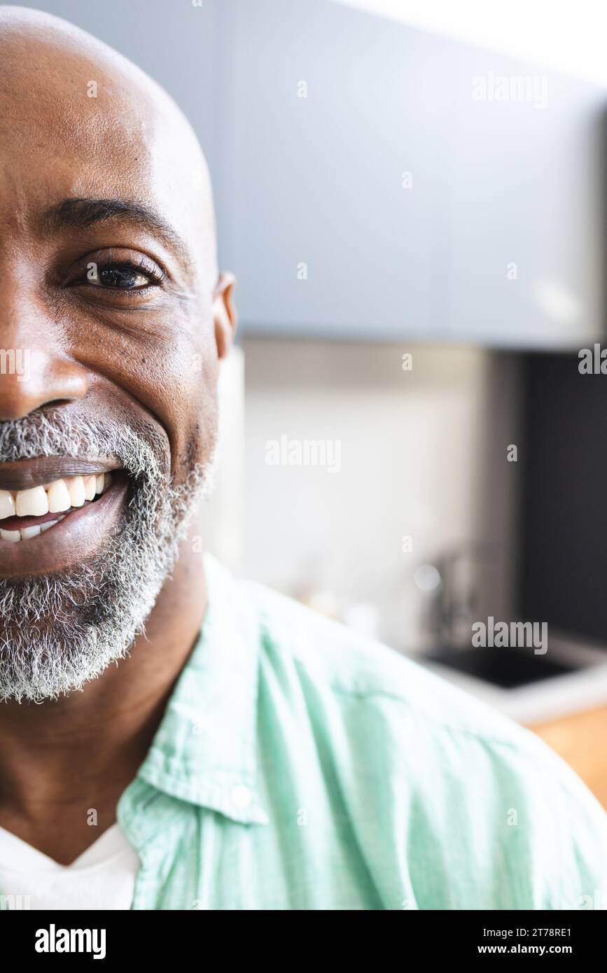 Halbporträt eines glücklichen, kahlköpfigen afroamerikaners, reifer Mann mit Bart, der in sonnigem Raum lächelt, Kopierraum Stockfoto