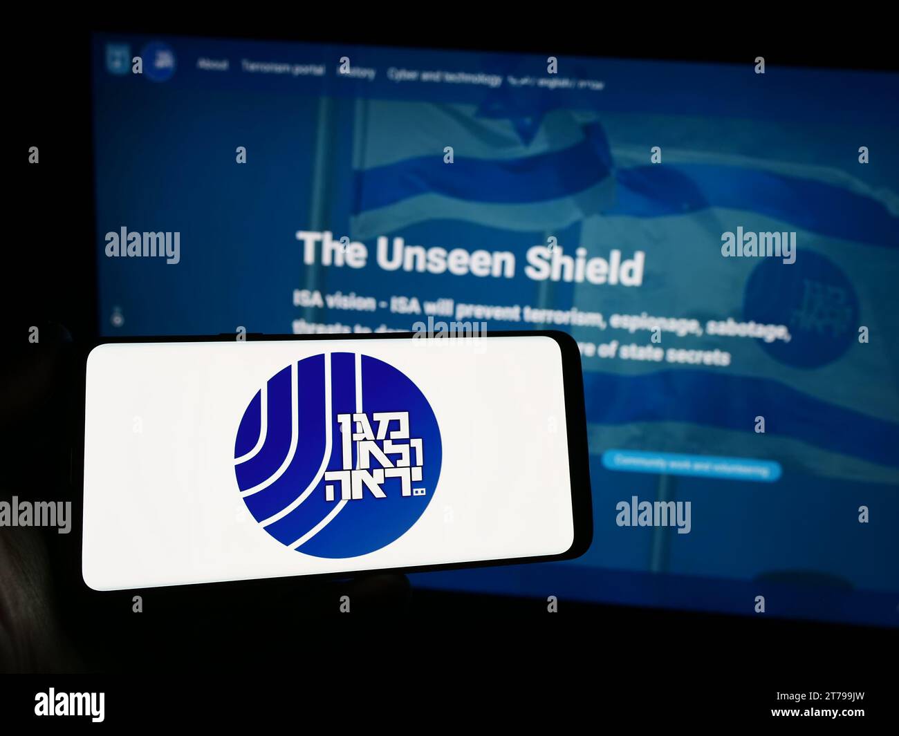 Person, die ein Smartphone mit dem Logo der israelischen Sicherheitsbehörde (ISA, Shin Bet) vor der Website hält. Schwerpunkt auf dem Display des Telefons. Stockfoto