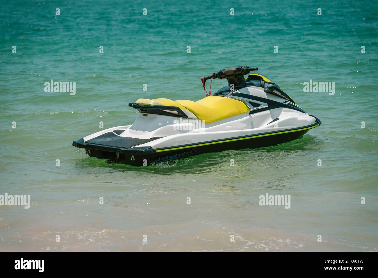 Weißer gelber Jetski in der Nähe der Küste, bereit zum Fahren, sonniger Tag, tropische Wassersportarten. Stockfoto