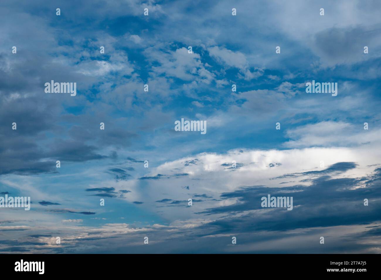 Ein Foto, das einen blauen Himmel mit weißen und grauen Wolken aufnimmt. Stockfoto