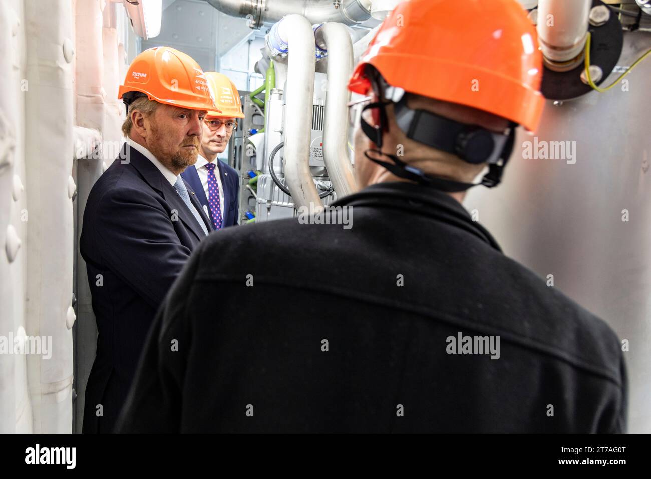 Duisburg, Deutschland. November 2023. Hendrik Wüst (CDU, M), Ministerpräsident von Nordrhein-Westfalen, und König Willem-Alexander von den Niederlanden (l) stehen im Maschinenraum eines Wasserstoffschiffes im Duisburger Hafen. Der niederländische König und der Ministerpräsident Nordrhein-Westfalens besuchen verschiedene Firmen und Einrichtungen. Quelle: Christoph Reichwein/dpa/Pool/dpa/Alamy Live News Stockfoto