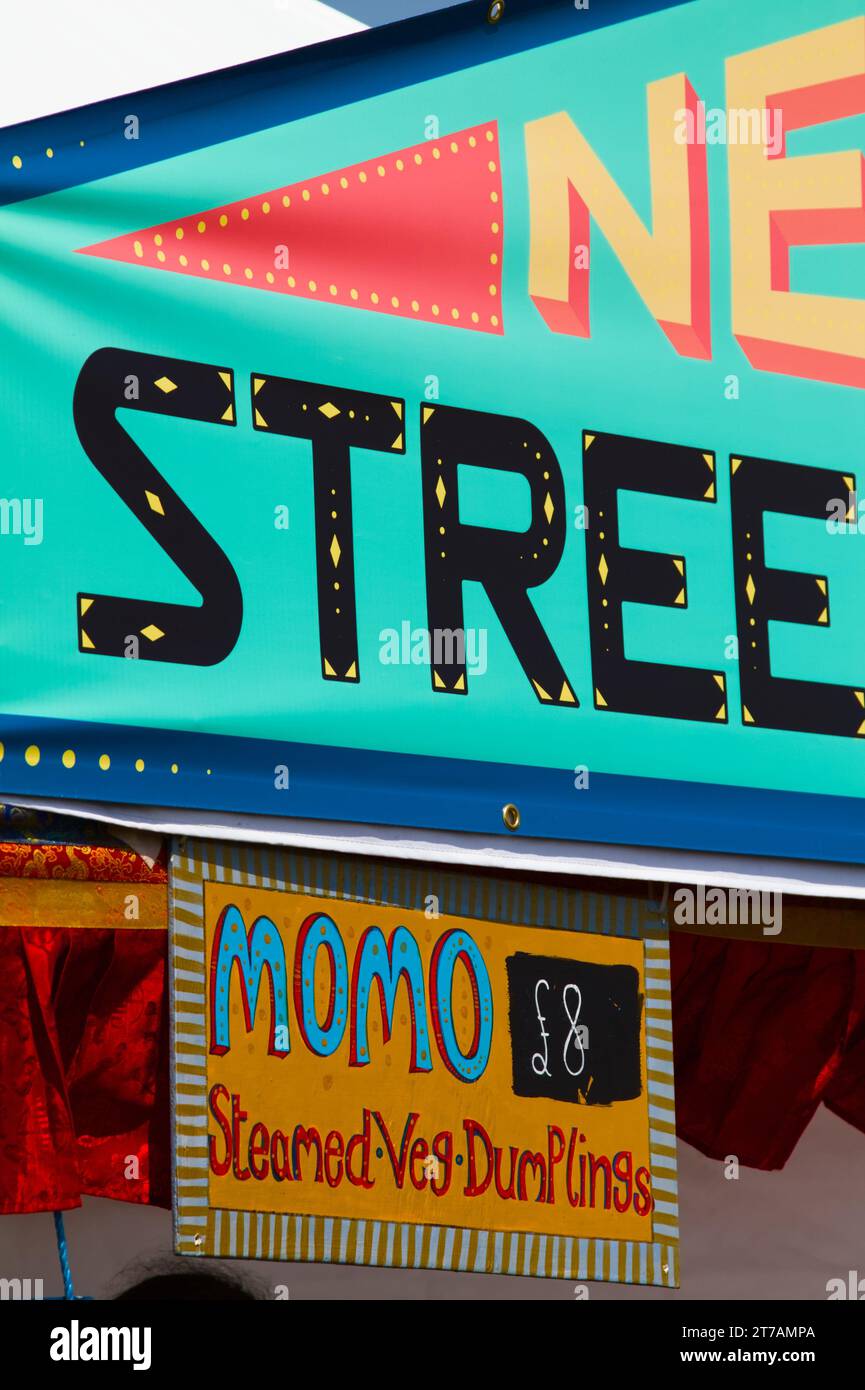Farbenfrohes Werbezeichen Eines Street Food Stalls, der Momo verkauft, Christchurch Food Festival, Christchurch UK Stockfoto