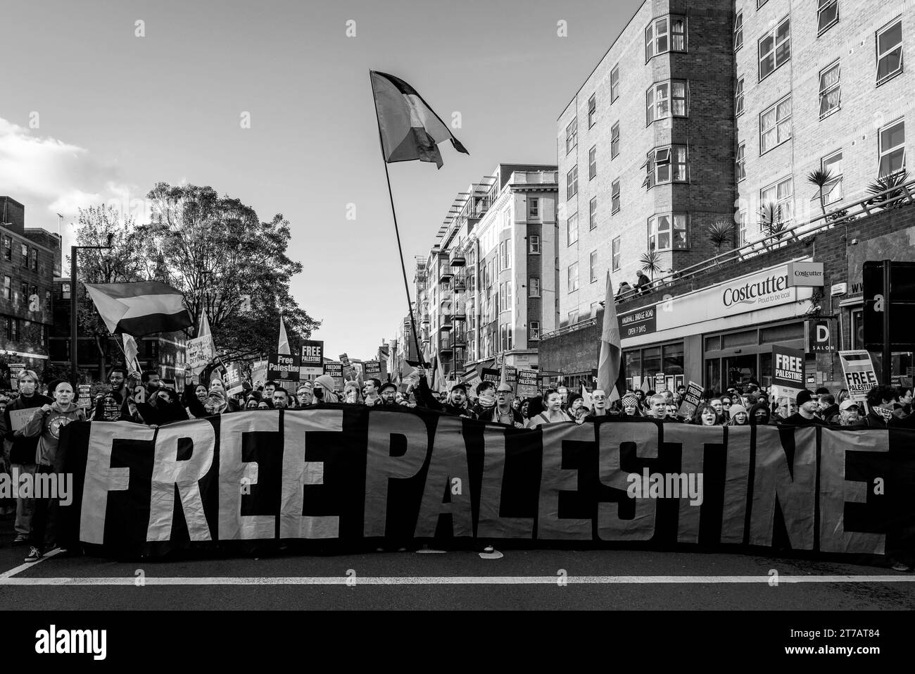Die Menschen marschieren durch Zentral-London mit Einem Banner für freies Palästina, das zu Einer Waffenruhe im Gazastreifen beim Marsch für Palästina in London, Großbritannien, aufruft Stockfoto