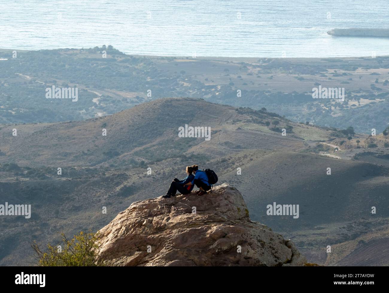 Ein junges Paar blickt von einem Felsvorsprung über Lara Bay, Akamas National Park, Akamas Halbinsel, Zypern Stockfoto