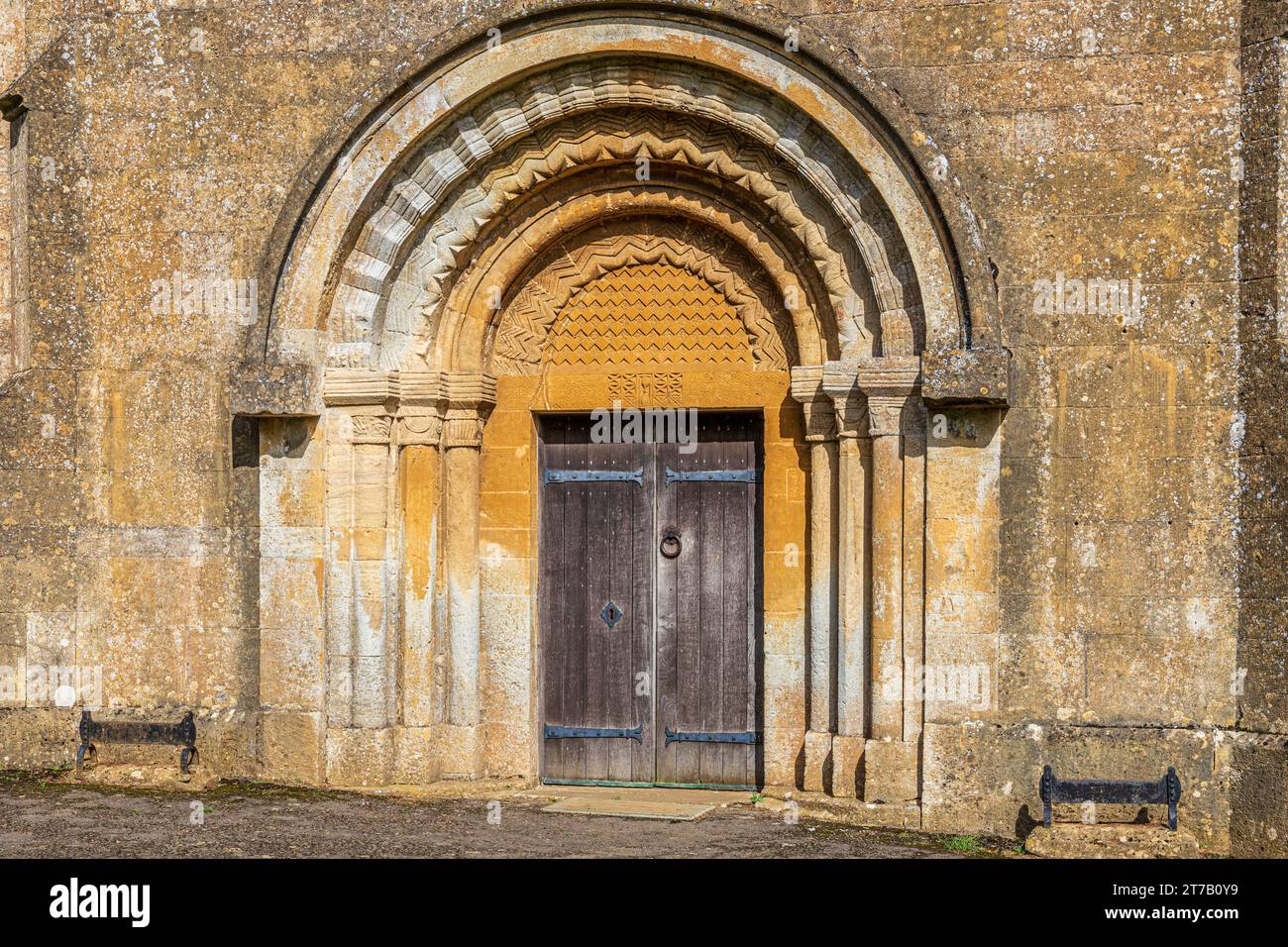 Eingang aus dem 12. Jahrhundert mit Rollen- und Chevron-Formteilen an der normannischen Kirche St. Michael im Cotswold-Dorf Guiting Power, Gloucestershire, Engla Stockfoto
