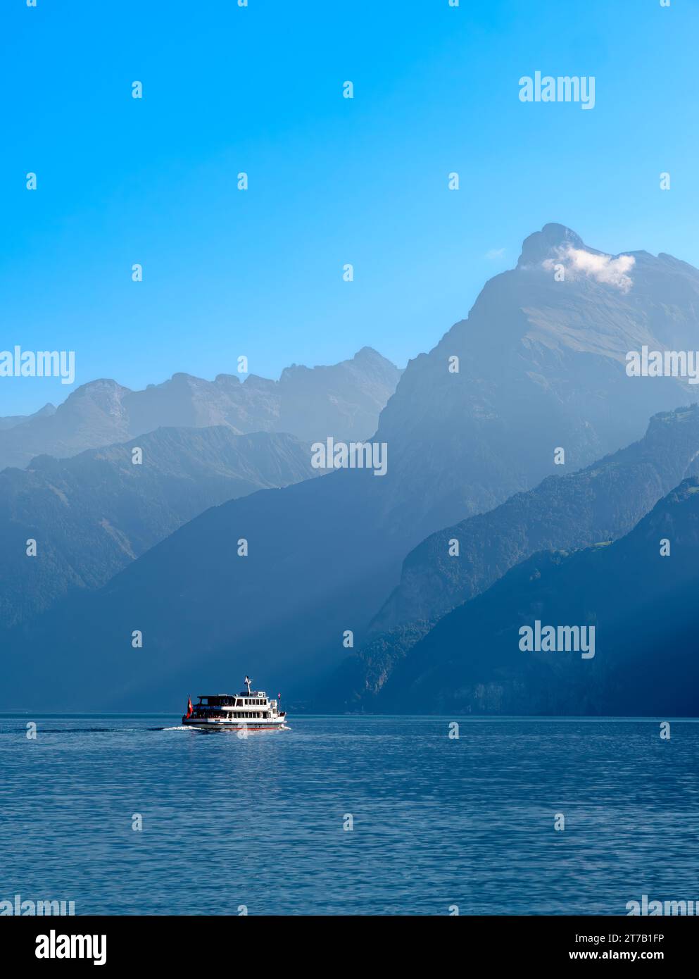 Umrisse der Berge am schweizerischen Urnersee - Luzerne See - im tagsüber trüben Licht. Touristenschiff auf dem See. Stockfoto
