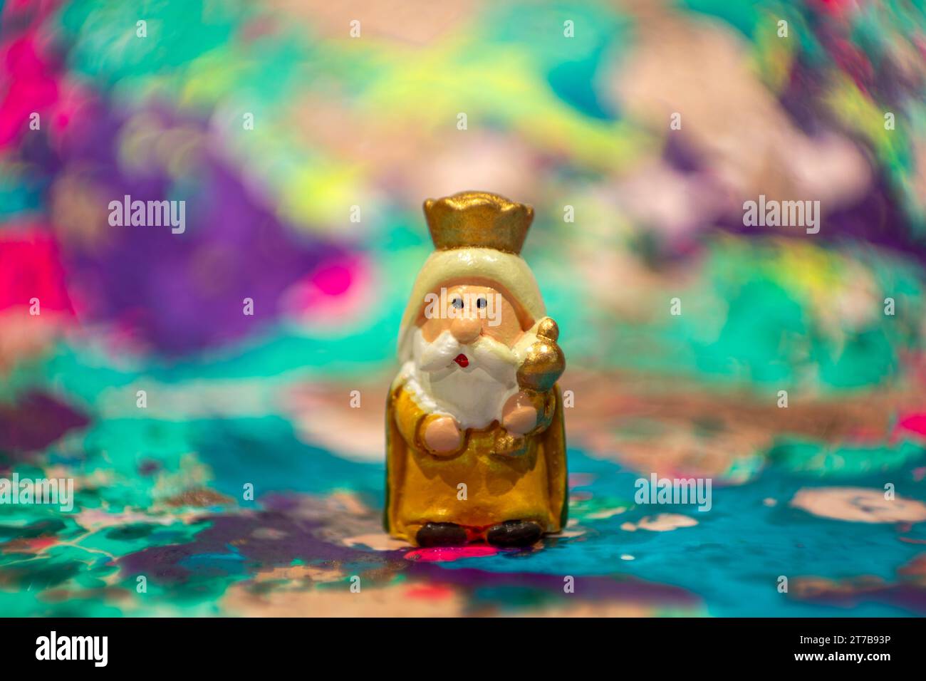 Der Weise Mann Melchior in handgemalter Tonfigur mit buntem und unscharfem Hintergrund Stockfoto