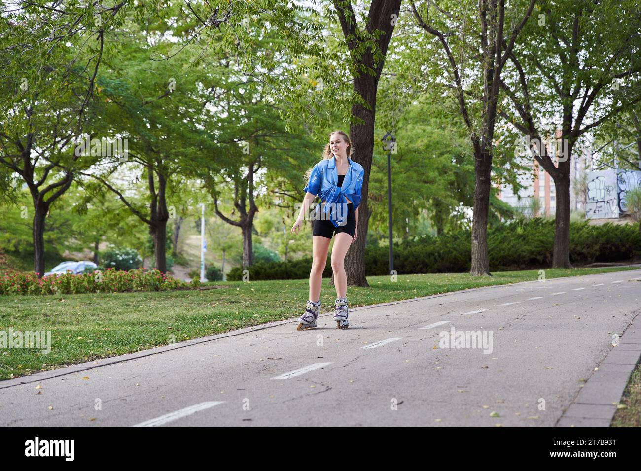 Blonde Frau, die mit Inlineskates Skateboarden fährt Stockfoto