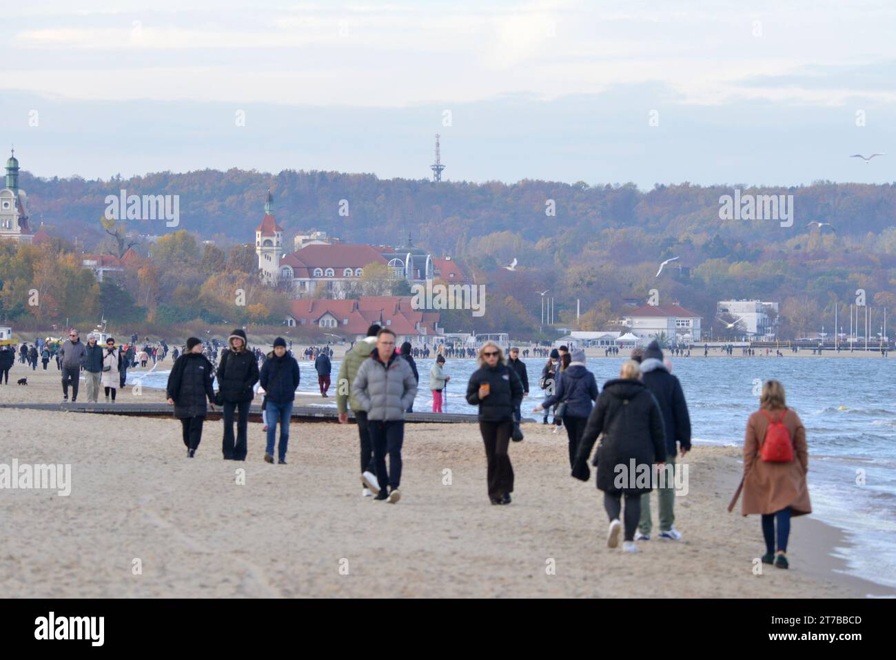 Menschen mit Jacken gehen am Danziger Strand in der Nähe von Sopot bei kaltem Wetter in Danzig, Polen, Europa, EU Stockfoto