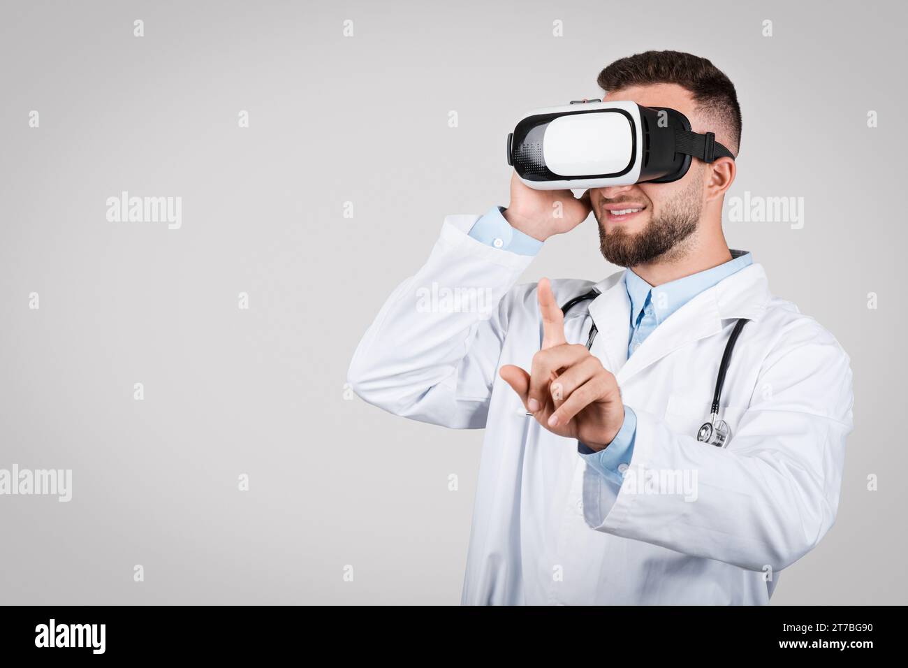 Doktor Mann mit VR-Headset, zeigt in die Luft Stockfoto