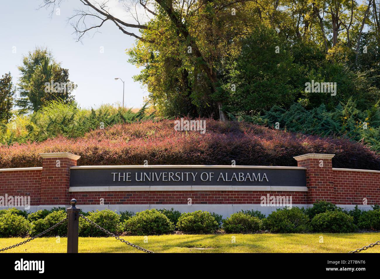 Das Schild der University of Alabama in Tuscaloosa, Alabama, auf einer Ziegelmauer mit schöner Landschaftsgestaltung Stockfoto