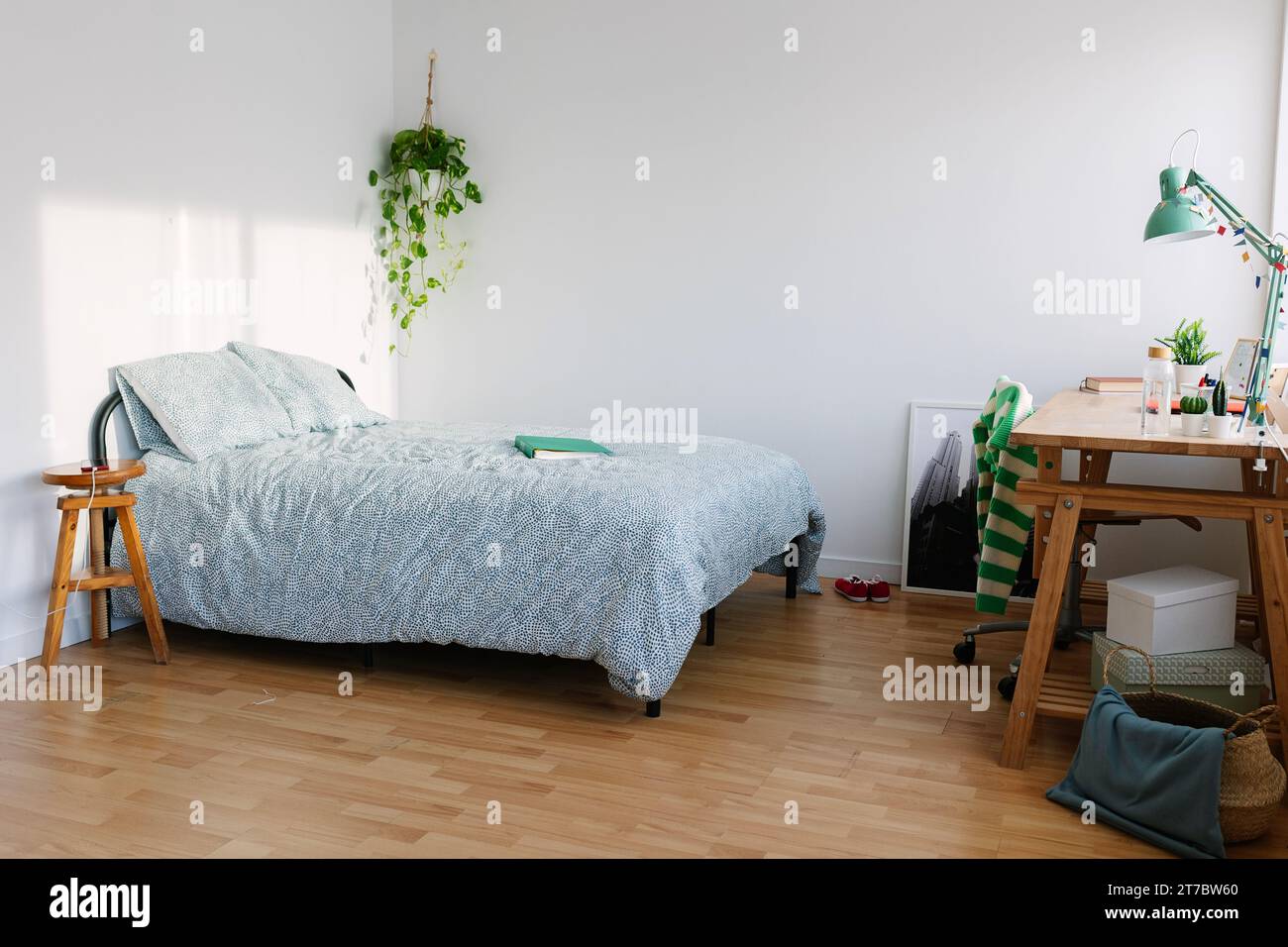 Gemütliches Innenzimmer eines tausendjährigen Teenagers mit Bett, Laptop und Schreibtisch Stockfoto