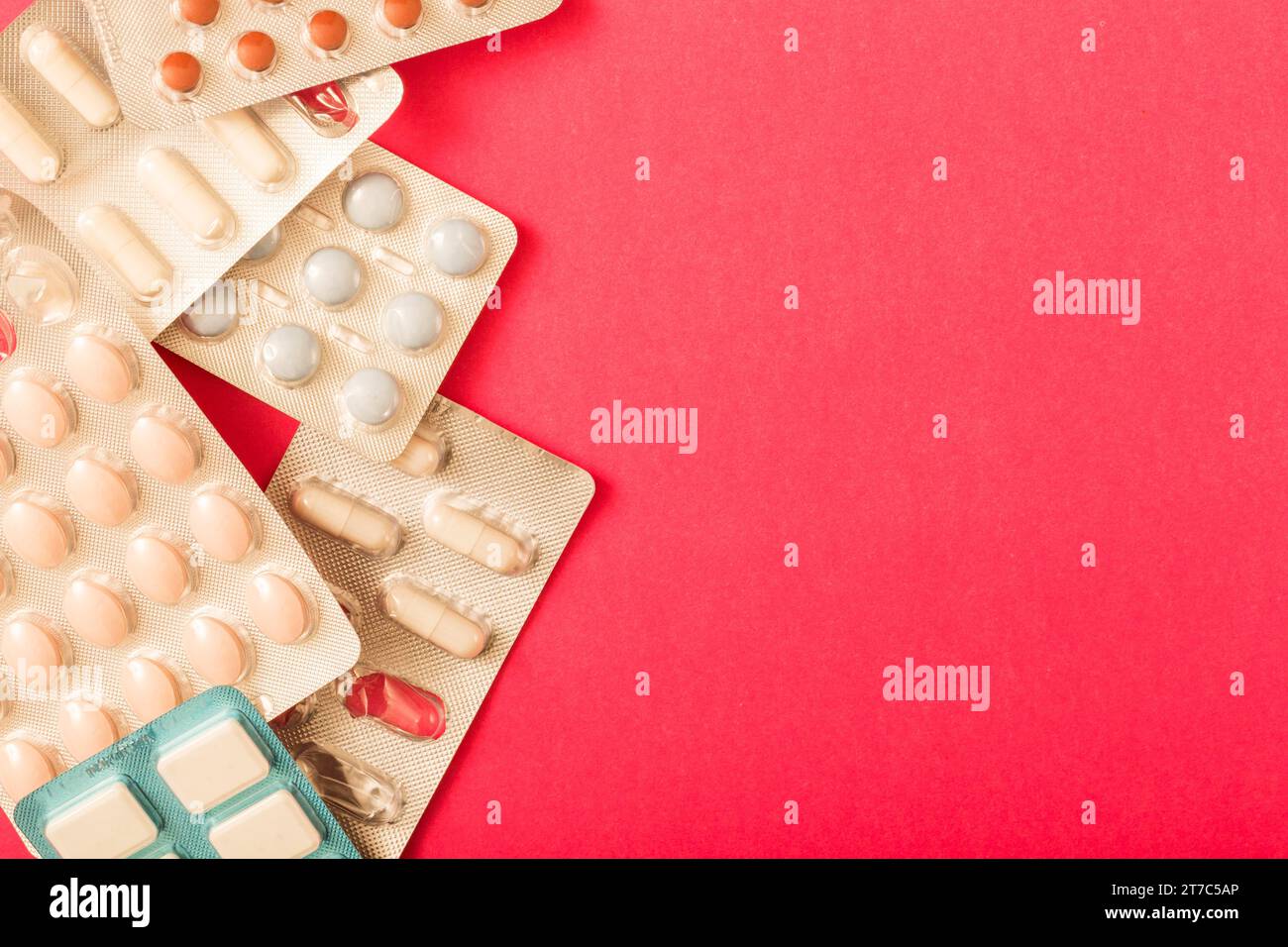 Verschiedene Pillen Blisterpackung roter Hintergrund Stockfoto