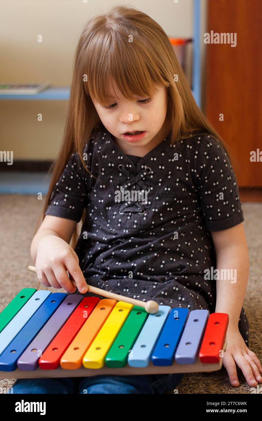 Mädchen mit Down-Syndrom, das mit Xylophon spielt Stockfoto