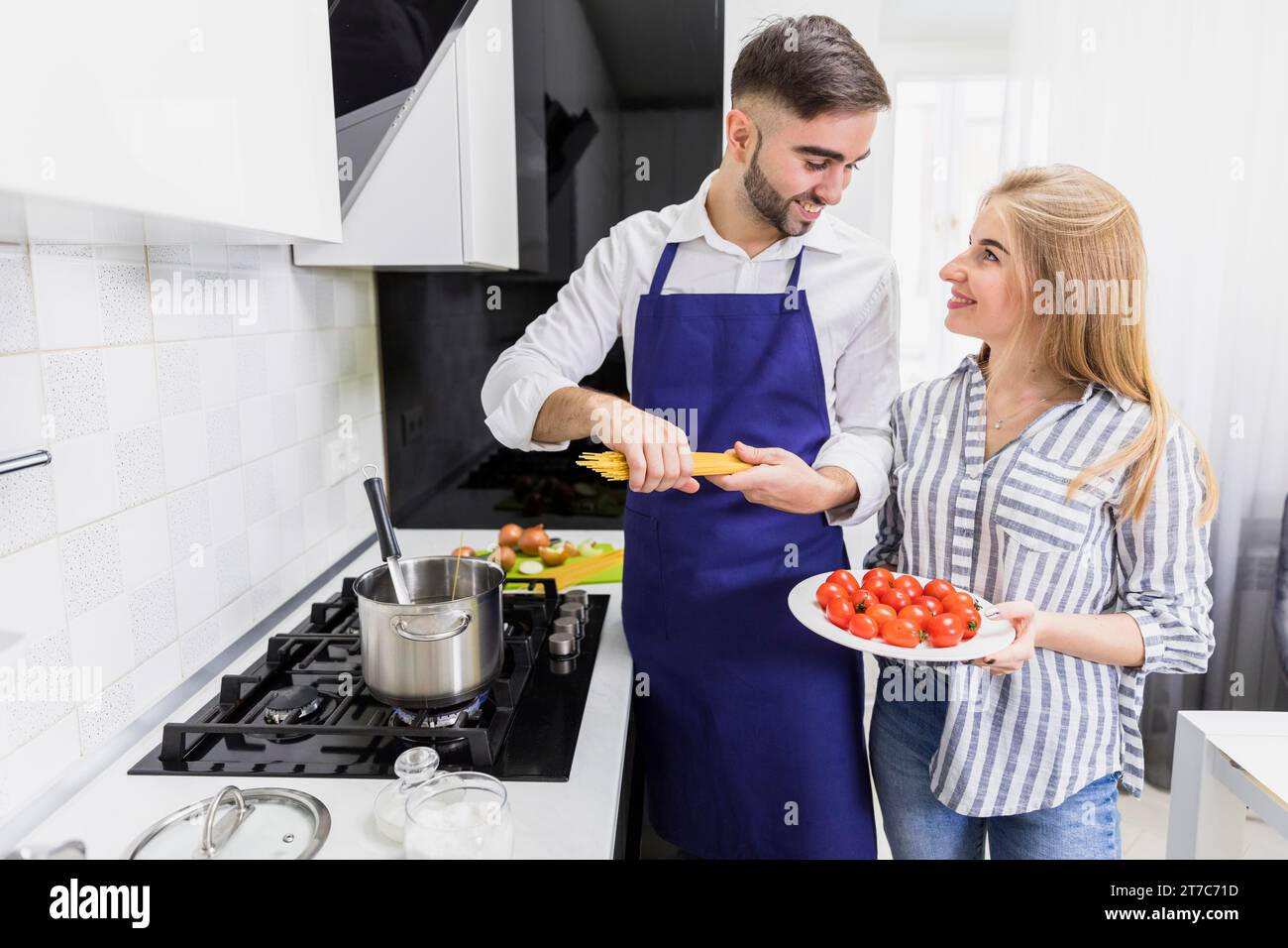 Glückliches Paar, das Spaghettitopf mit gekochtem Wasser macht Stockfoto