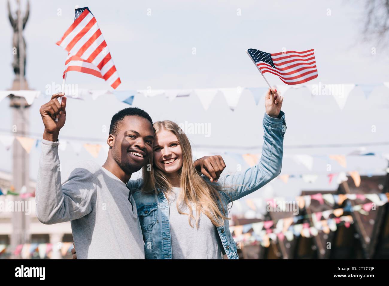 Multiethnische Freunde, die amerikanische Fahnen hielten, streckten die Hände aus Stockfoto