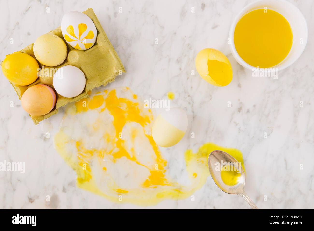 Gelber ostereierbehälter in der Nähe von Löffelfarbstoff-Flüssigkeit Stockfoto