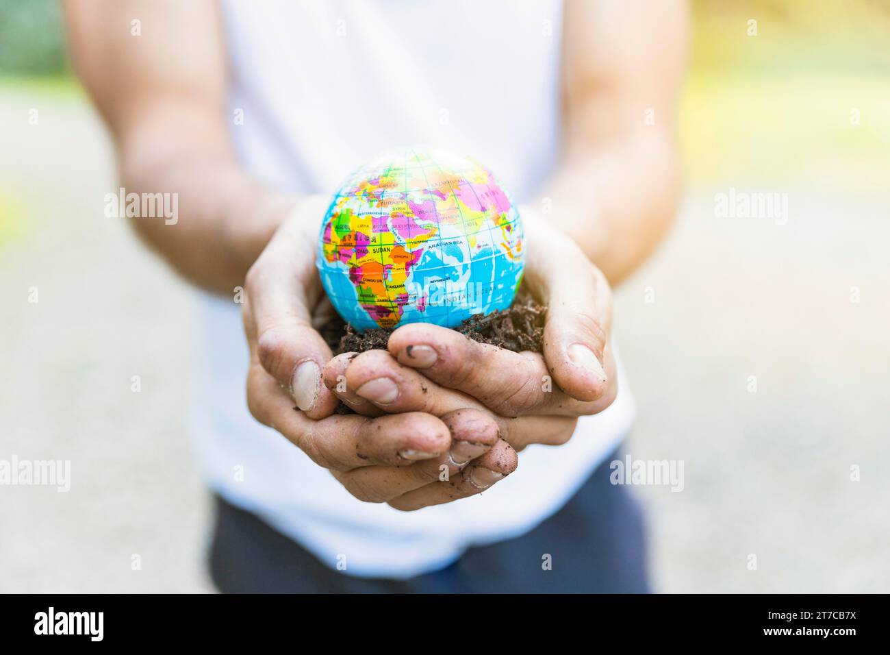 Männliche Hände, die einen kleinen Globus halten Stockfoto