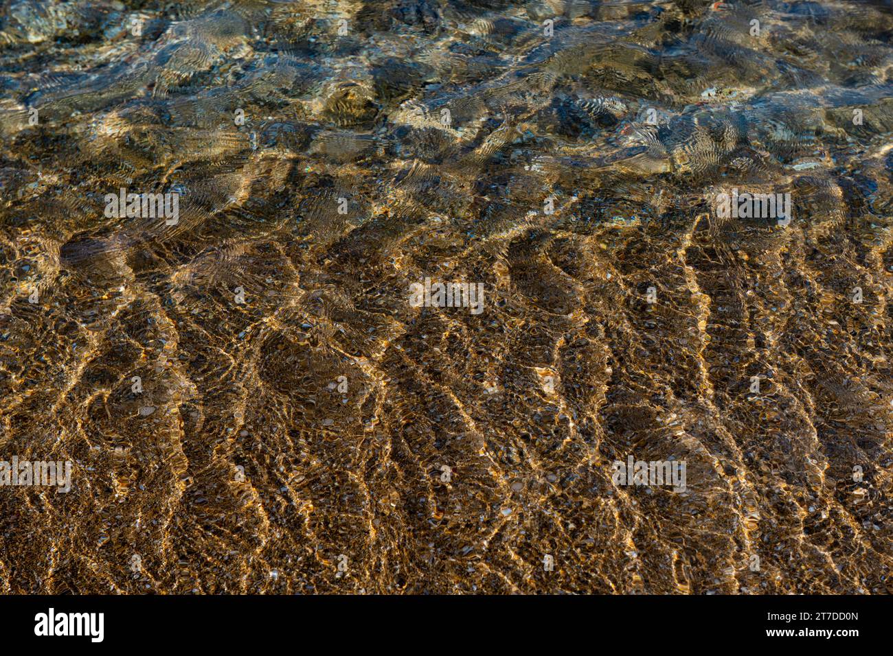 Aquamarine und gelbe Wellen über den strukturierten Sandrivulets an der Küste der Mittelmeerküste in Israel. Stockfoto