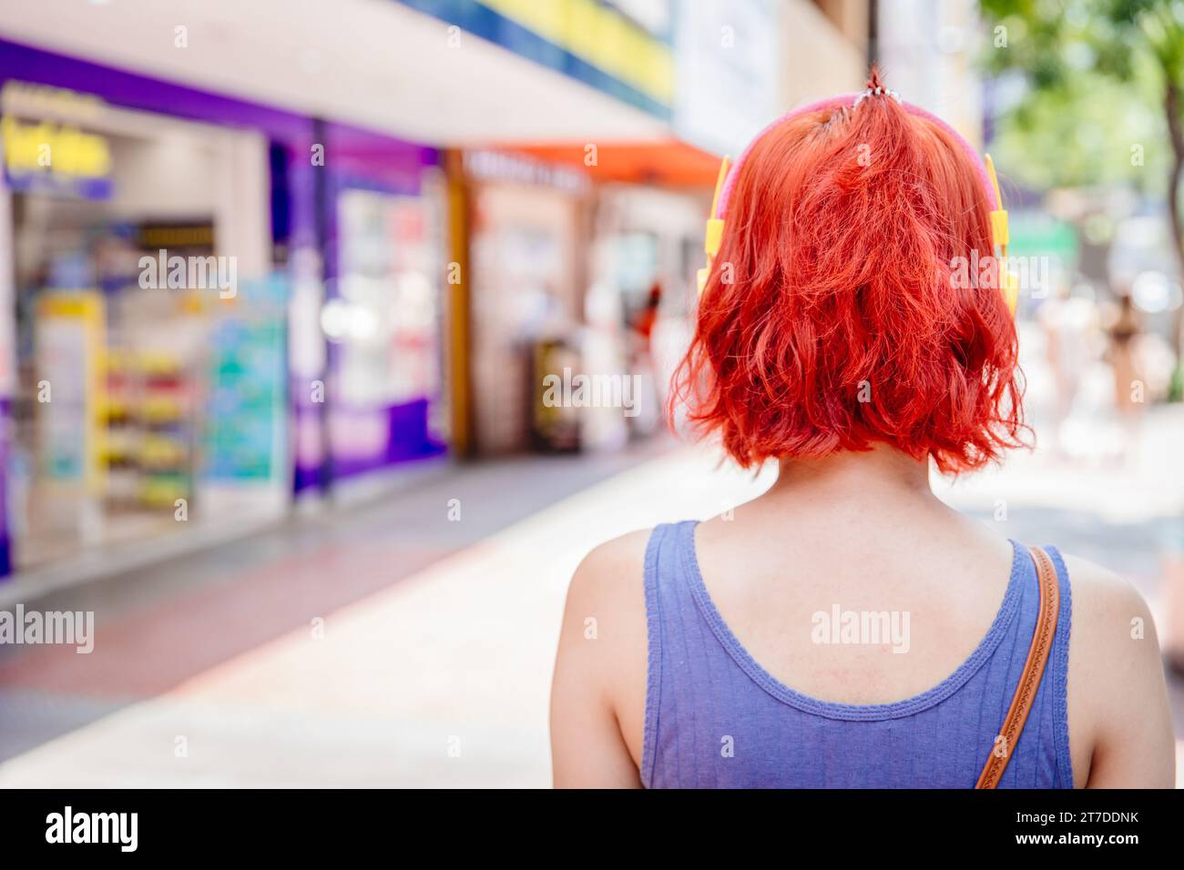 Trendige Damen zum Frisuren. Hipster moderner Lifestyle junge Frau rote Haare Farbe Reise im Freien öffentliche Einkaufsstraße Rückansicht Stockfoto