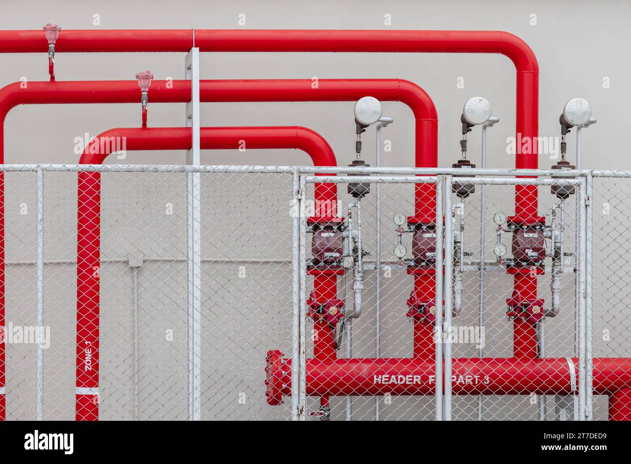 Sprinkleralarm, Hochdruck-Wasserversorgungsleitung mit Überdruckventil im Industriegebäude des Sicherheitszaunbereichs Stockfoto