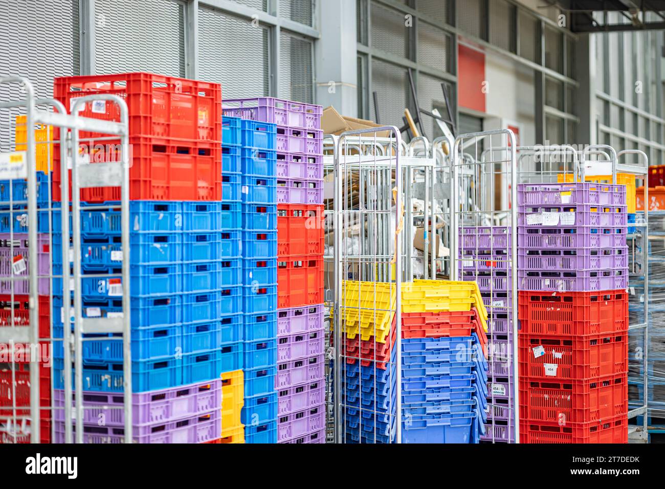 Hinter einem Lebensmitteleinzelhandelsgeschäft stapelbare Kunststoffkisten für Supply Chain-Produkte, Versand, Vertrieb und Konsum von Geschäftsmärkten. Stockfoto