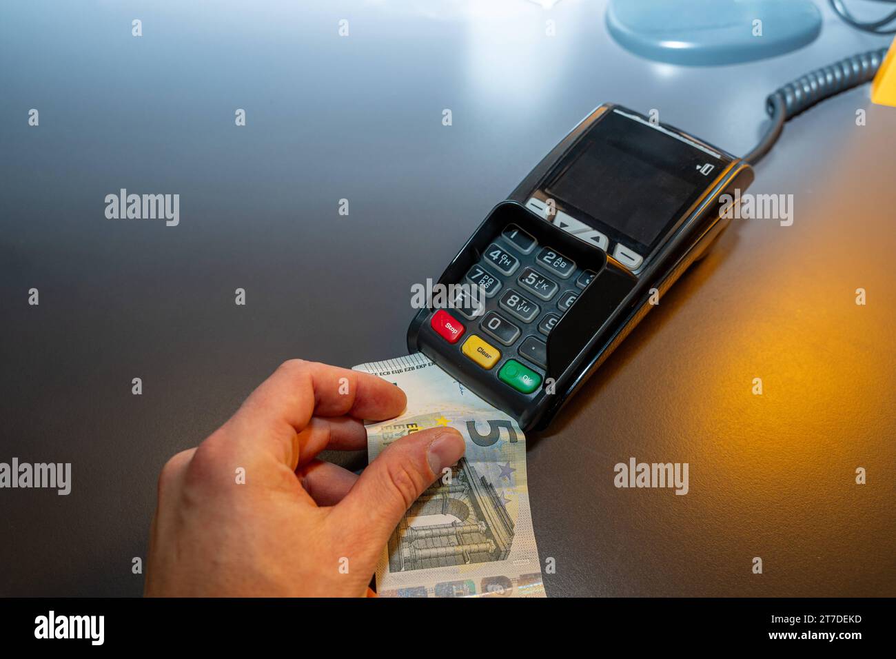 Augsburg, Bayern, Deutschland - 21. Juni 2023: Hand mit einem 5-Euro-Schein an einen EC-Kartenleser. Symbolbild der Bargeld- und Kartenzahlung *** Hand halten 5-Euro Schein an ein EC-Kartenlesegerät. Symbolbild Bargeld und Kartenzahlung Credit: Imago/Alamy Live News Stockfoto