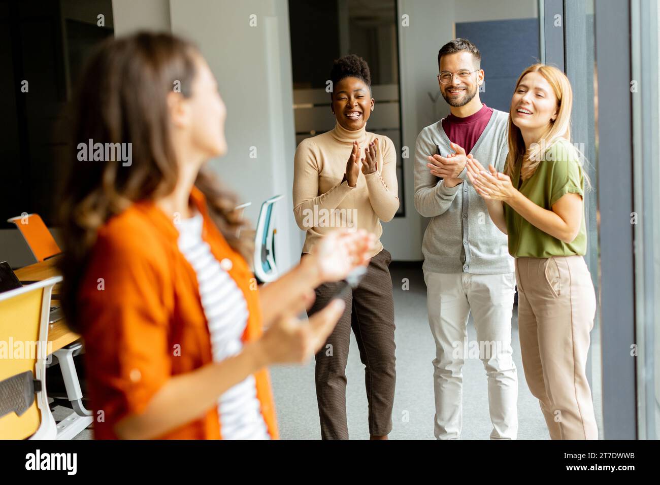 Junge Geschäftsfrau, die vor ihrem Team im modernen Büro steht Stockfoto