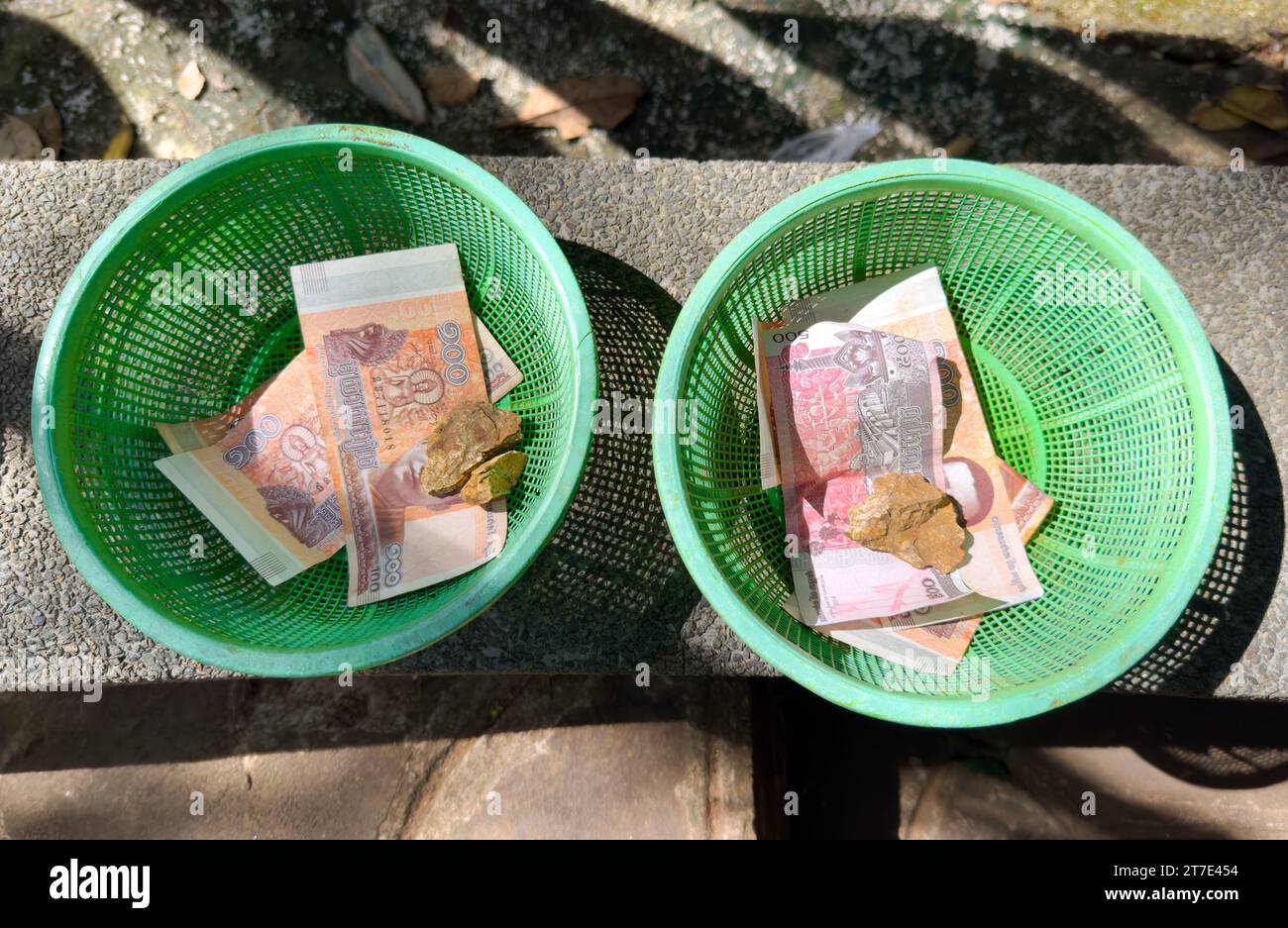 Spendenschalen aus Plastik mit Bargeld darunter für eine Ausstellung der 12 BuddhistJataka-Geschichten, Oudong-Tempel in der Provinz Kandal, Kambodscha. Die Geschichte von Jataka Stockfoto