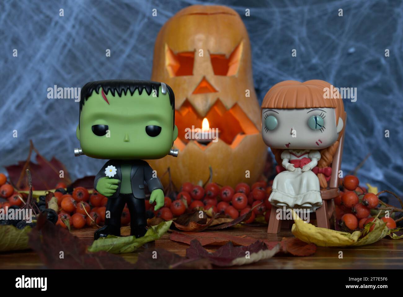 Funko Pop Actionfiguren von Frankensteins Monster und Spukpuppe Annabelle. Halloween, Jack o Laterne, Spinnennetz, Herbstblätter. Stockfoto