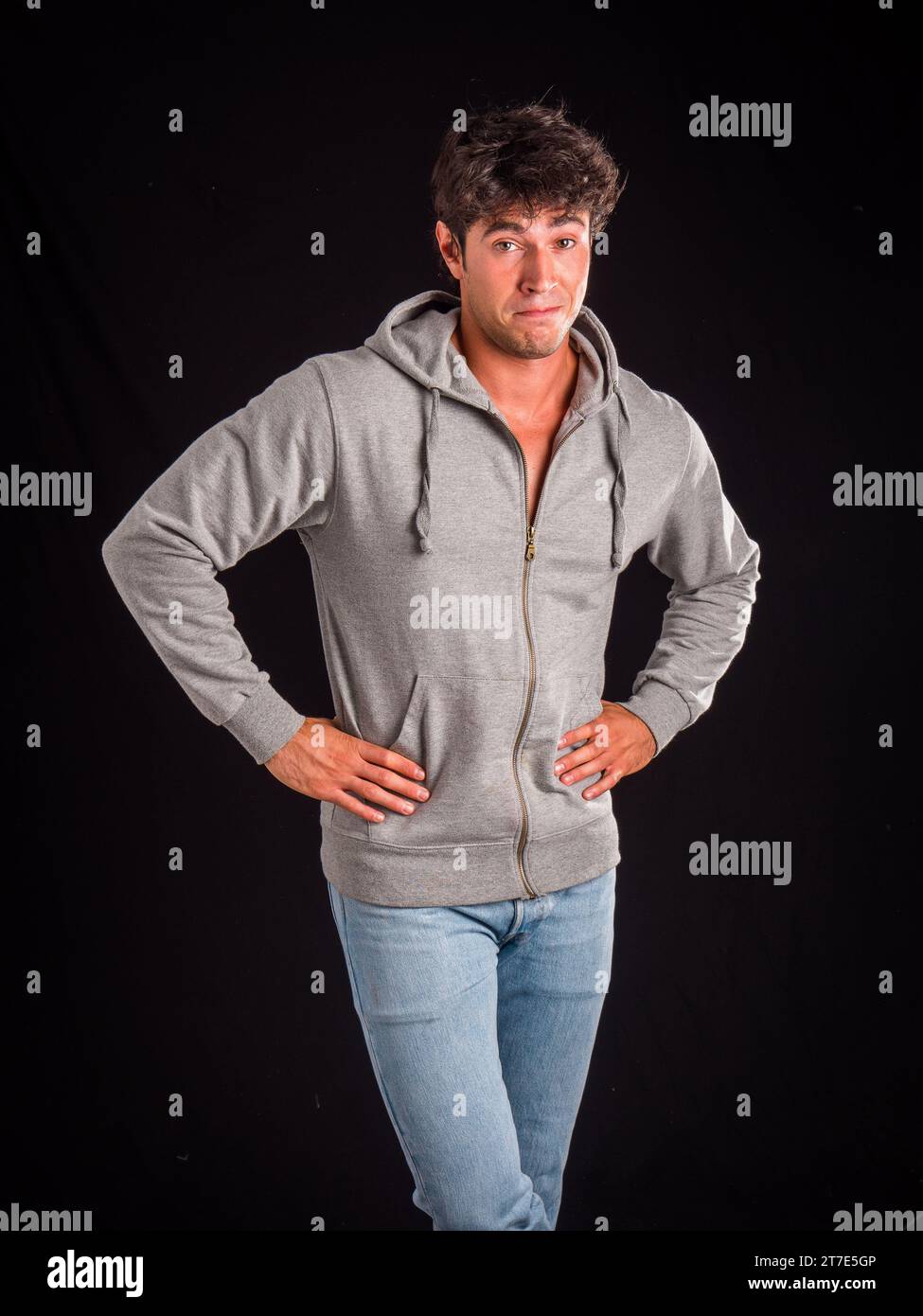 Ein Mann in einem grauen Hoodie posiert für ein Bild Stockfoto