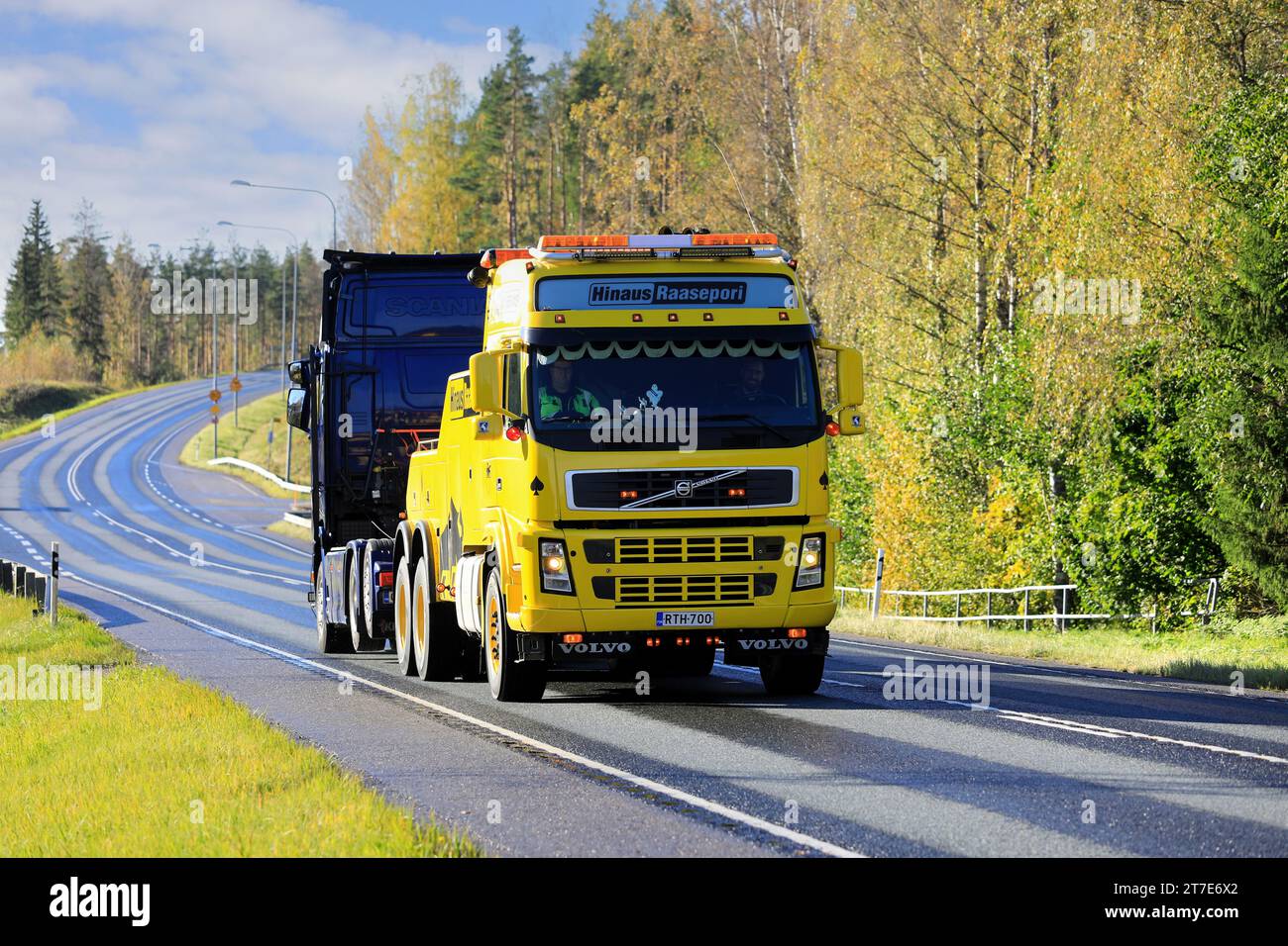 Gelbes Volvo FH Hochleistungs-Bergungsfahrzeug von Hinaus Raasepori, das im Herbst einen Sattelschlepper entlang der Autobahn zieht. Raasepori, Finnland. Oktober 2023. Stockfoto