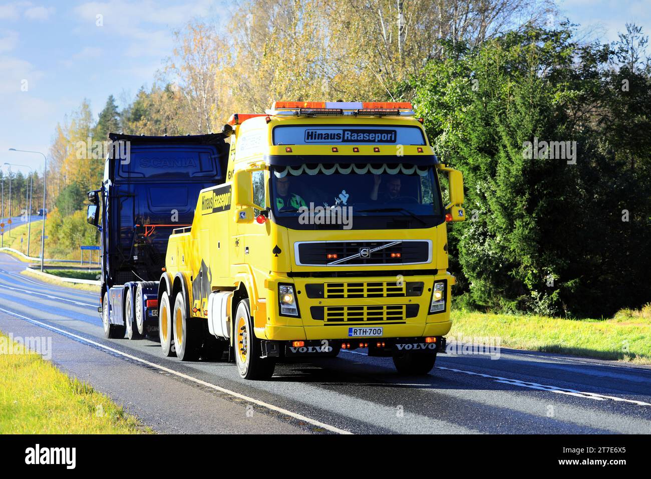 Gelbes Volvo FH Hochleistungs-Bergungsfahrzeug von Hinaus Raasepori, das im Herbst einen Sattelschlepper entlang der Autobahn zieht. Raasepori, Finnland. Oktober 2023. Stockfoto