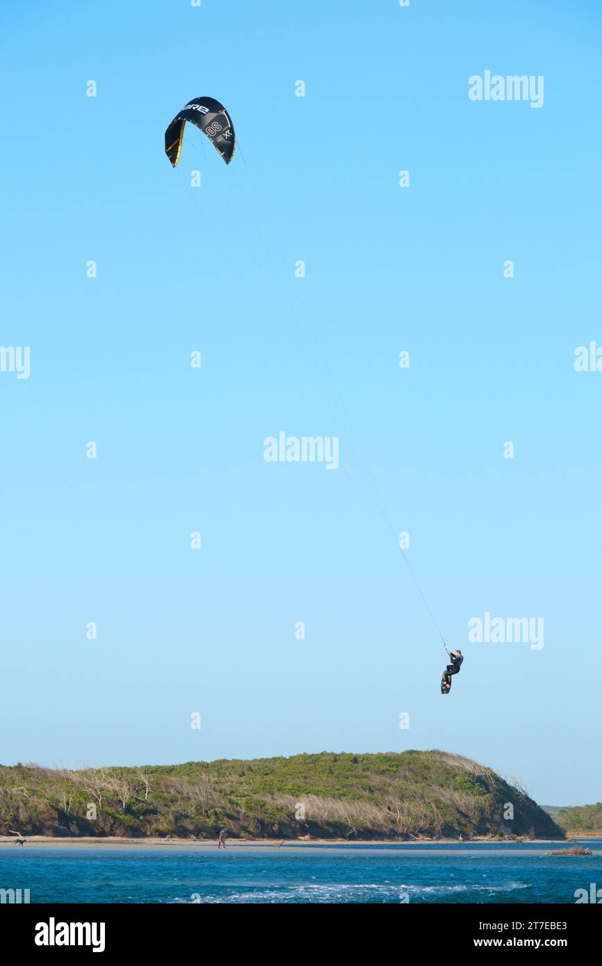 Vertikales Bild eines Kitesurfers, der während des Kitesurfens an der Mündung des Blackwood River in Hardy Inlet, Augusta, Südwest-Australien, in der Luft landet. Stockfoto