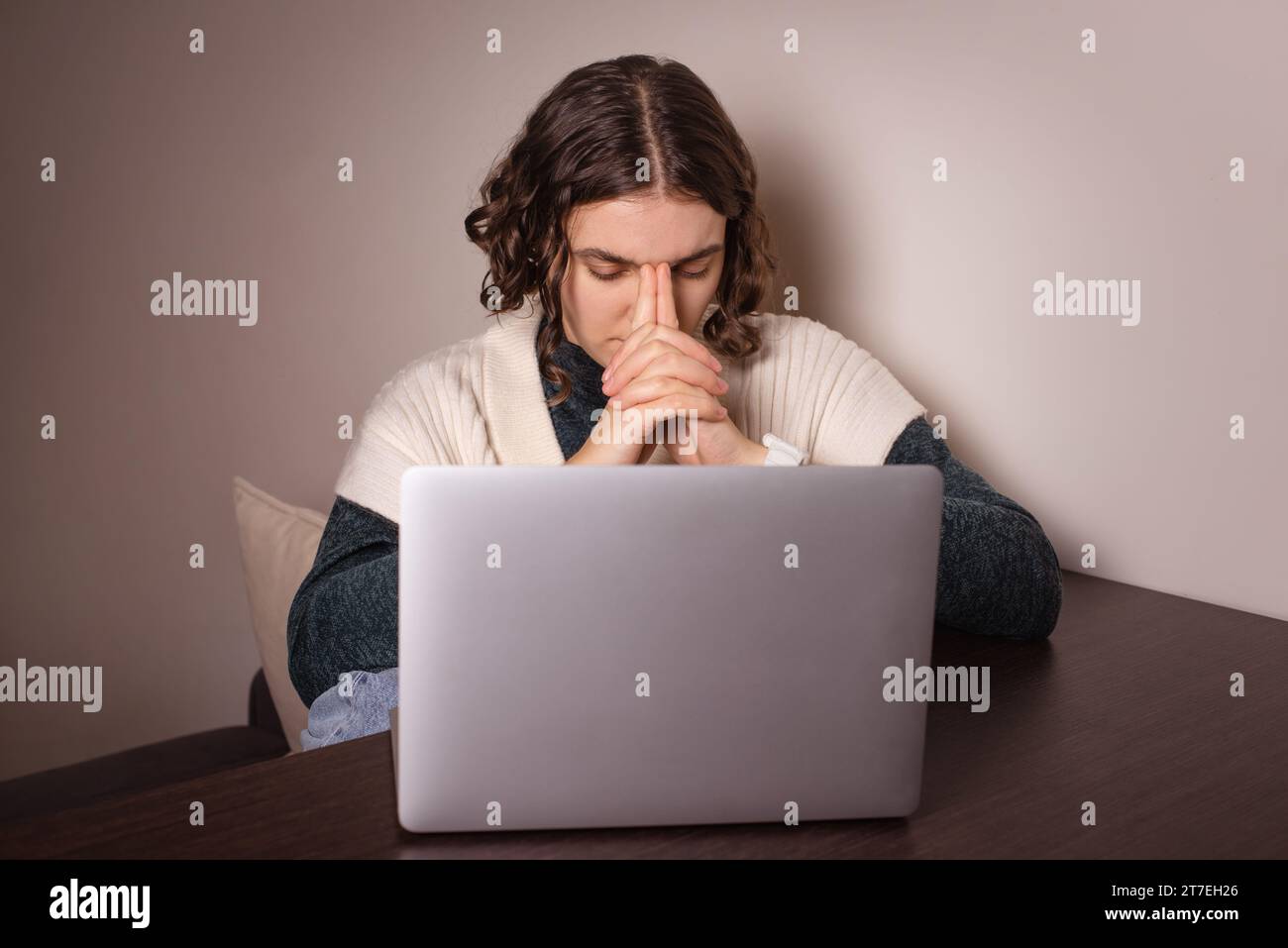 Besorgte Frau, die mit Laptop sitzt, Angst hat. Weiblich gestresst, eine harte Entscheidung treffen Stockfoto