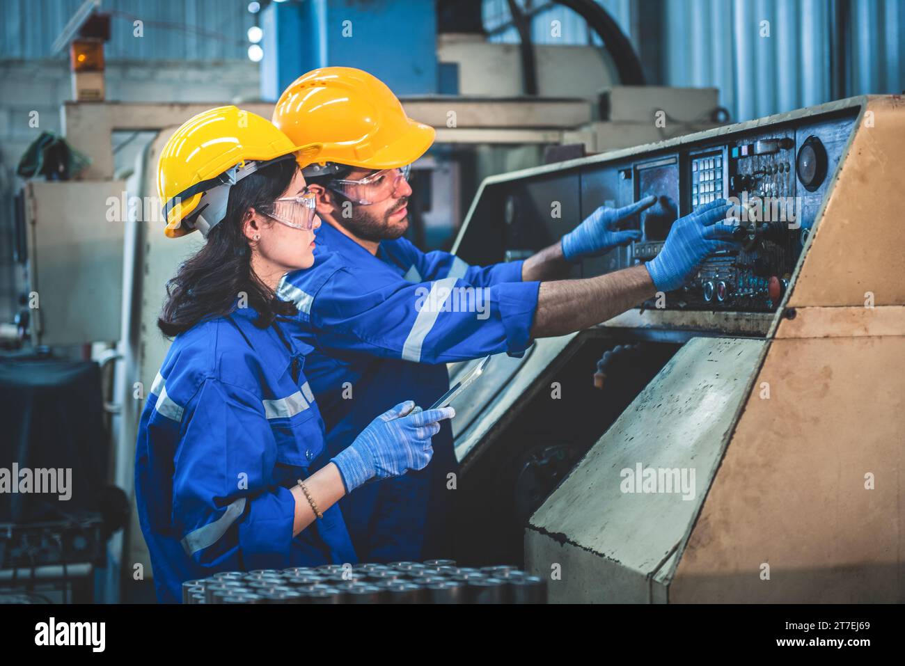 Porträt der Arbeiter in der Schwerindustrie, die an der Metallverarbeitung arbeiten, indem sie eine Drehmaschine an einer Maschine für die Stahlstrukturindustrie betreiben. Stockfoto