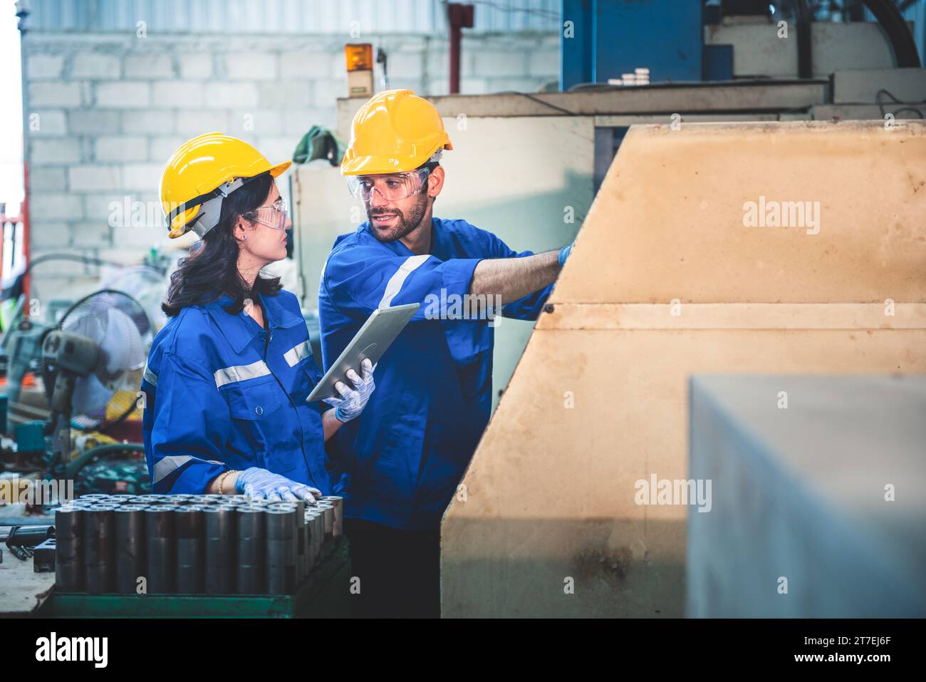 Porträt der Arbeiter in der Schwerindustrie, die an der Metallverarbeitung arbeiten, indem sie eine Drehmaschine an einer Maschine für die Stahlstrukturindustrie betreiben. Stockfoto