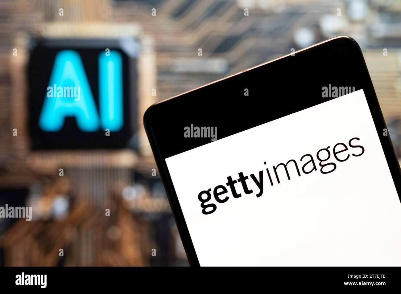 In dieser Fotoabbildung zeigt das amerikanische Unternehmen für visuelle Medien und Lieferant von Stockfotos sowie das Getty Images-Logo (NYSE: GETY) auf einem Smartphone mit einem Chip für künstliche Intelligenz (KI) und einem Symbol im Hintergrund. Stockfoto