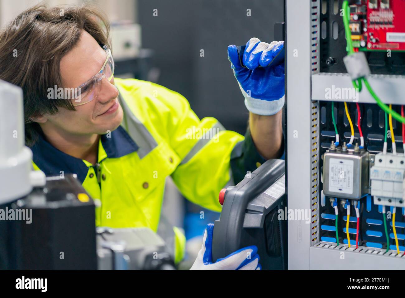 Elektroingenieur-Prüfgerät zur Messung von Spannung und Strom von Stromleitungen in der Schaltschranksteuerung für die industrielle Produktion. Stockfoto