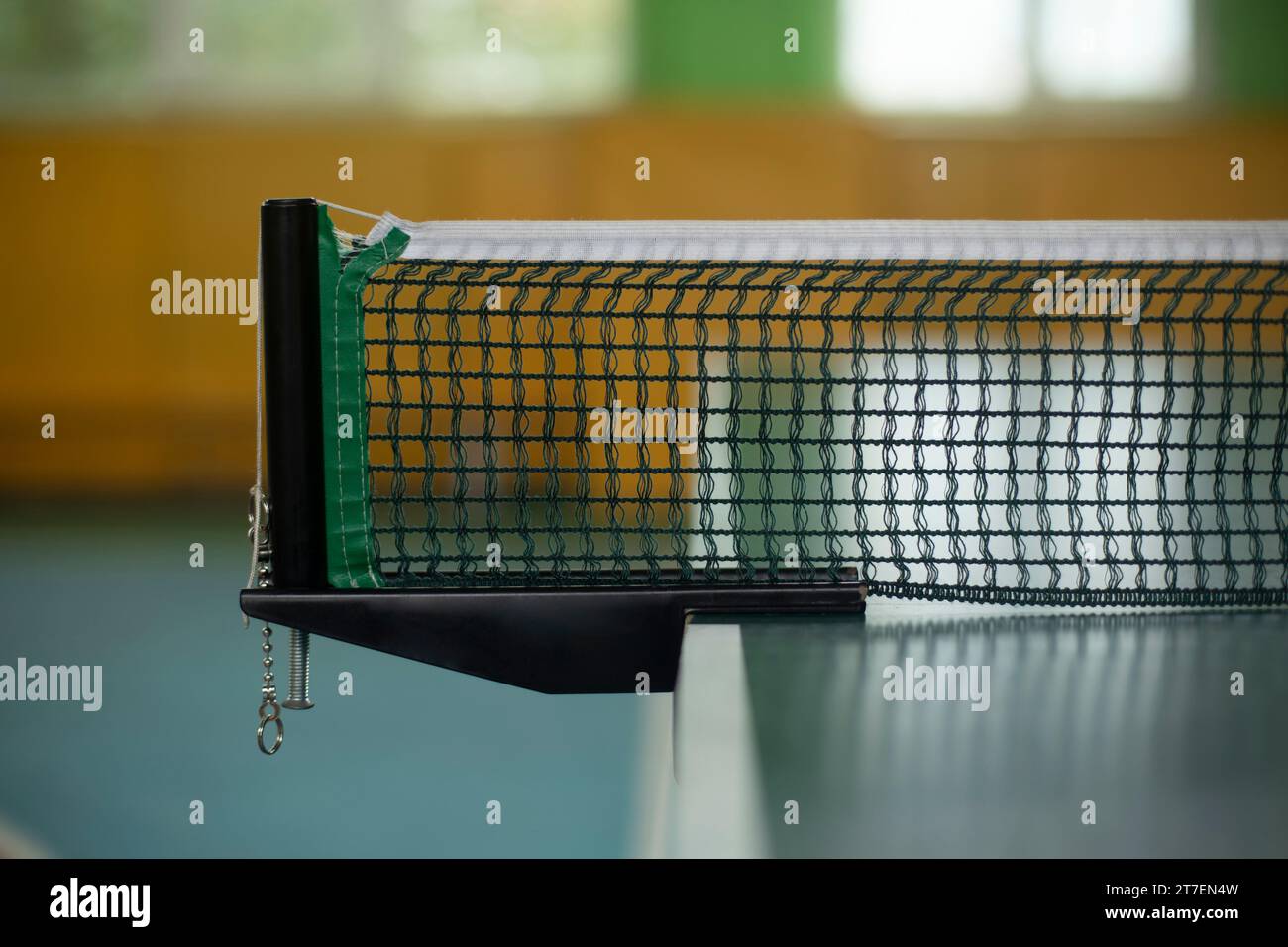 Tischtennisnetz. Netz auf dem Tennistisch. Details zur Sportausrüstung. Fitnessstudio in der Schule. Stockfoto