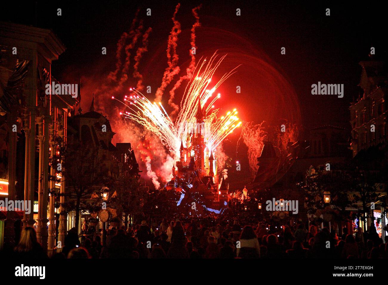 Rotes Feuerwerk beim Euro disney in paris mit Schloss und Zuschauermenge im Blick Stockfoto