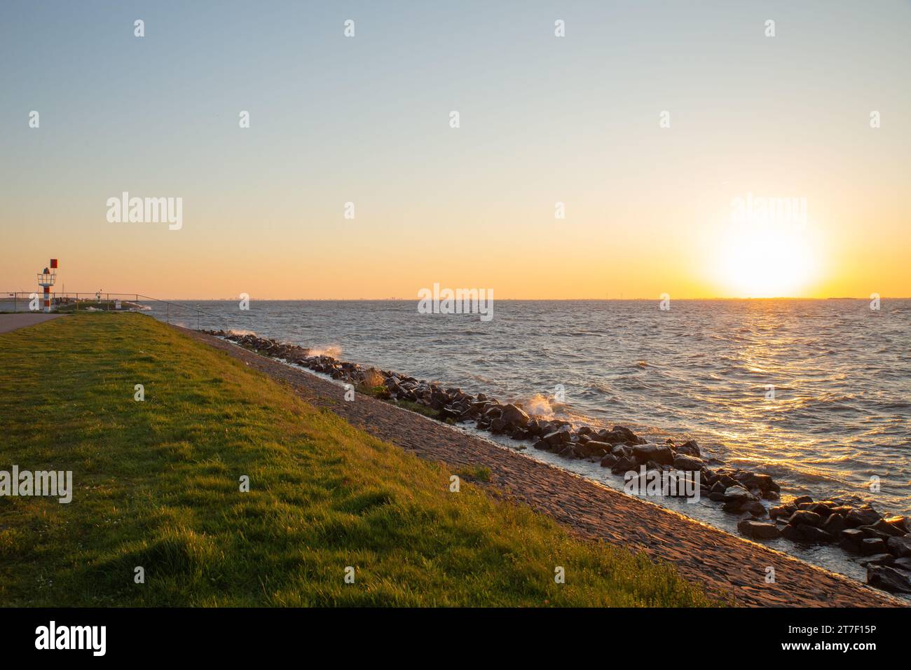 Sonnenuntergang am Meer mit Wellen, die die Küste treffen Stockfoto