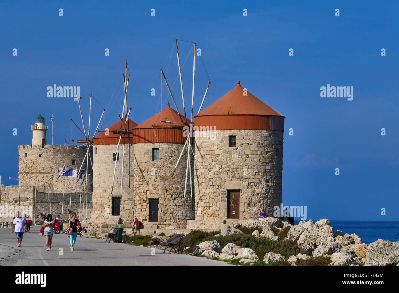 Die Windmühlen und der Leuchtturm an der Mündung des Hafens von Mandraki auf der Insel Rhodos in Griechenland. Stockfoto