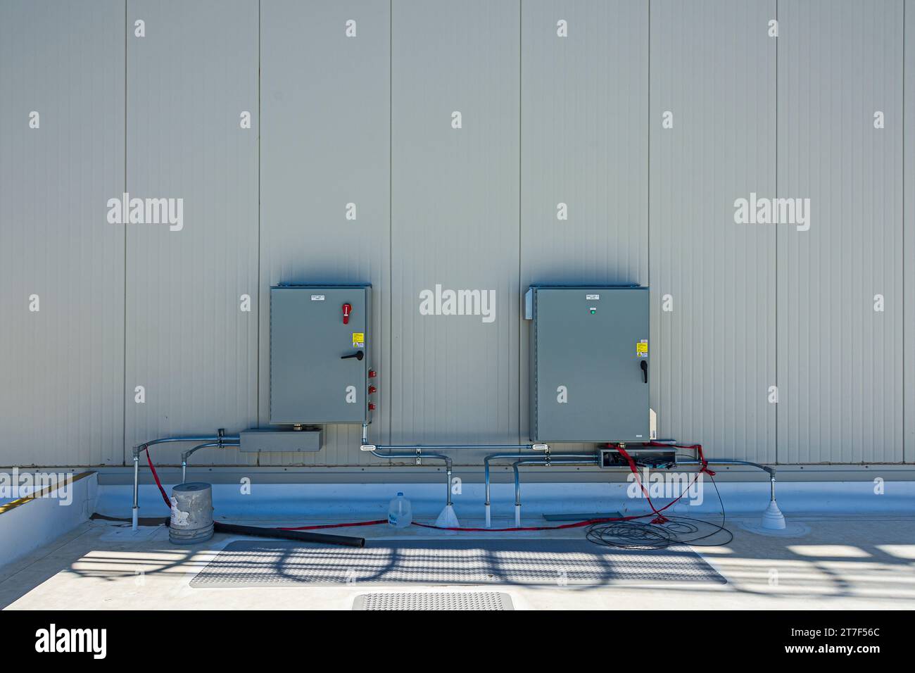 Elektrische Schalttafeln an der Außenwand auf dem Dach des Kühllagergebäudes (Industriekühlung) während der Bauarbeiten. Stockfoto