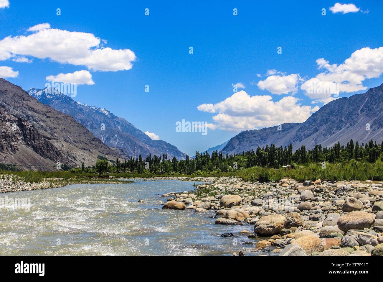 Der ruhige Tanz eines fließenden Flusses vor einer majestätischen Bergkulisse. Wo Ruhe auf Pracht trifft und jede Kräuselung eine Geschichte erzählt. Stockfoto