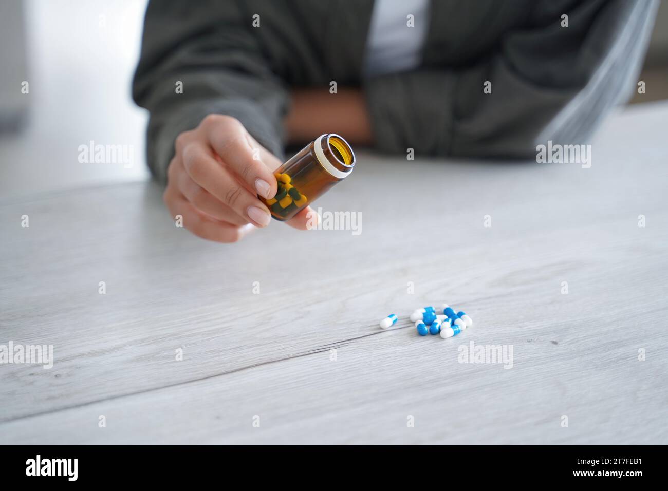 Hand-Ausgießen von Pillen aus einer Flasche, ein Konzept des Medikamentenmanagements Stockfoto