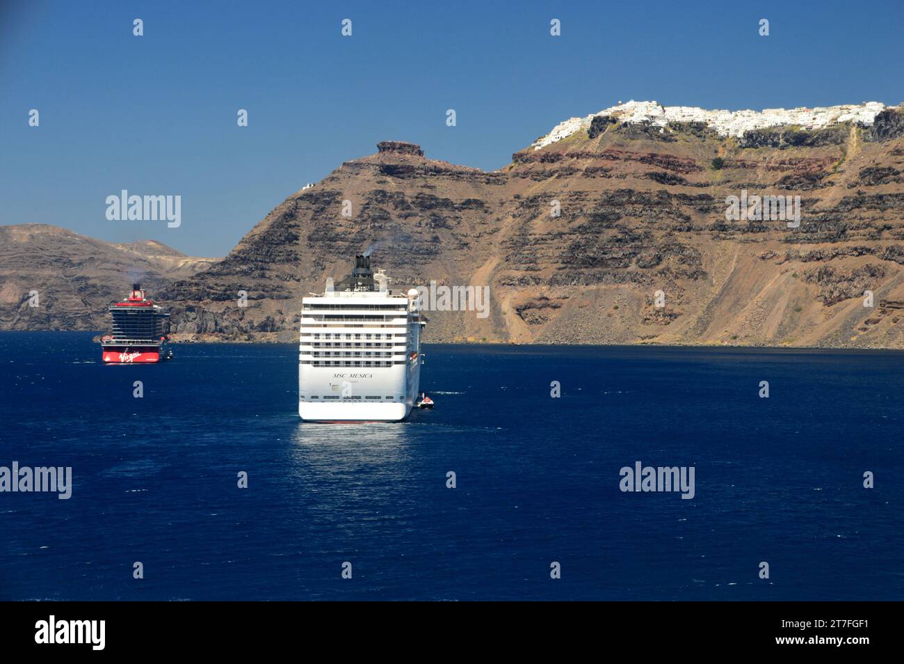 Virgin Voyages 'Resilient Lady' und MSC Cruises 'MSC Muscia' Luxus Kreuzfahrtschiffe unter den Klippen von Santorin, Kykladen Inseln, Ägäis, Griechenland. Stockfoto